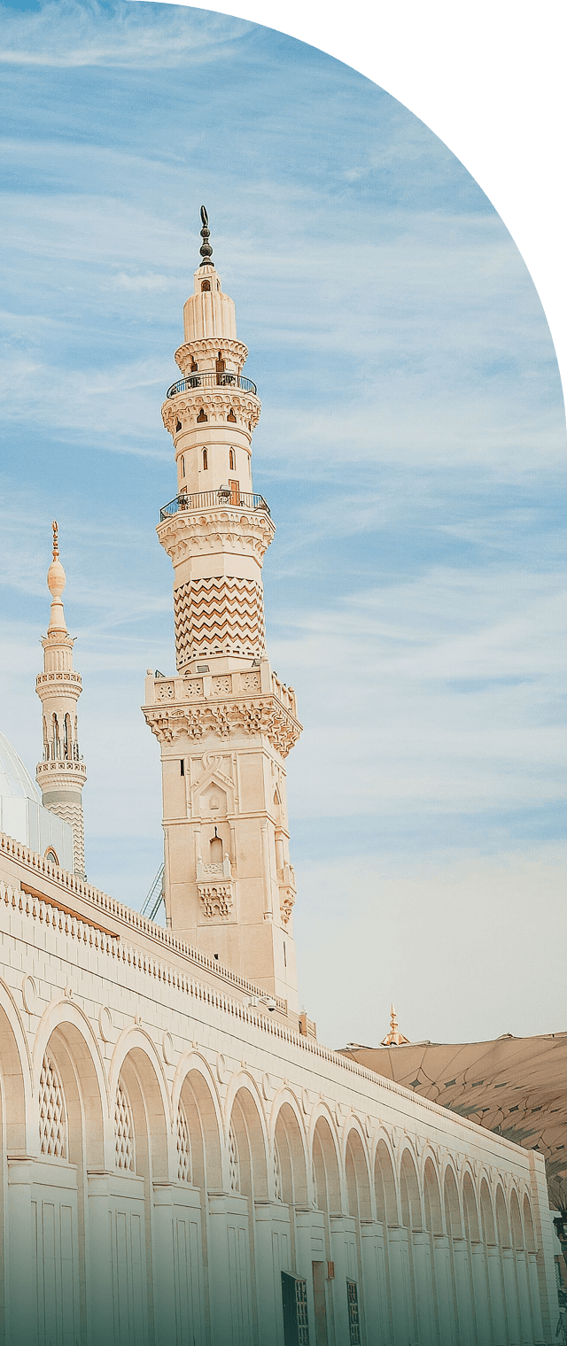 A minaret of Masjid al-Nabawi rising above the arcade at first light