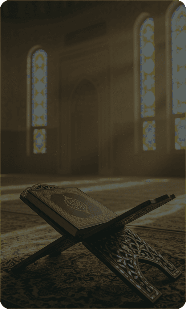 A Quran open on a carved rehal in a prayer hall lit by stained glass
