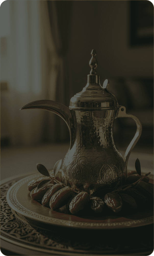 A brass dallah standing on an engraved tray of dates