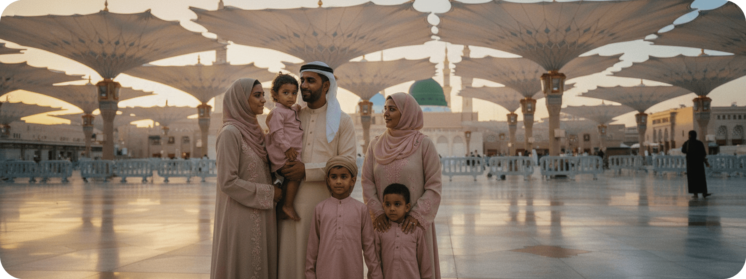 A family standing together beneath the canopies of Masjid al-Nabawi at sunset