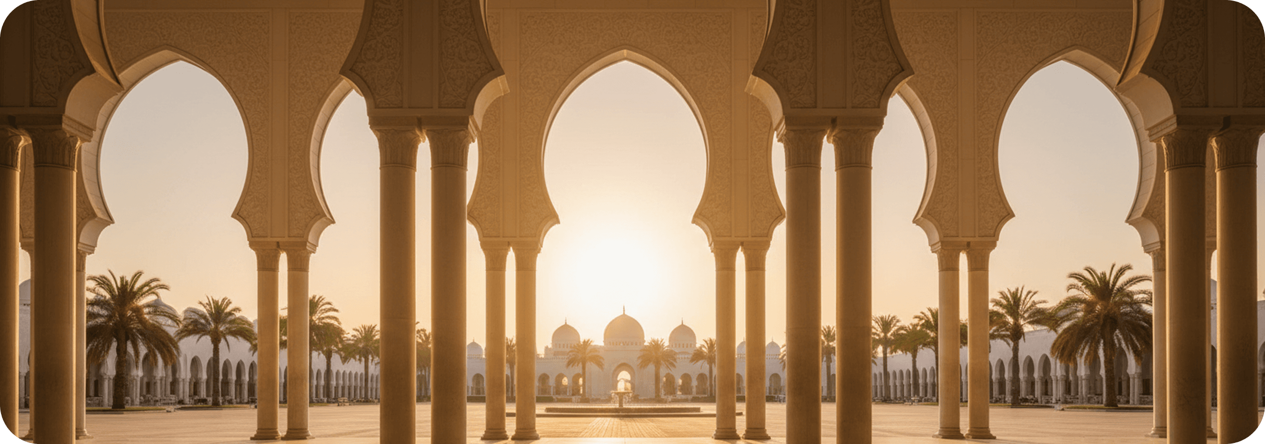Sunrise through the arches of a mosque colonnade, looking across the courtyard to the prayer hall