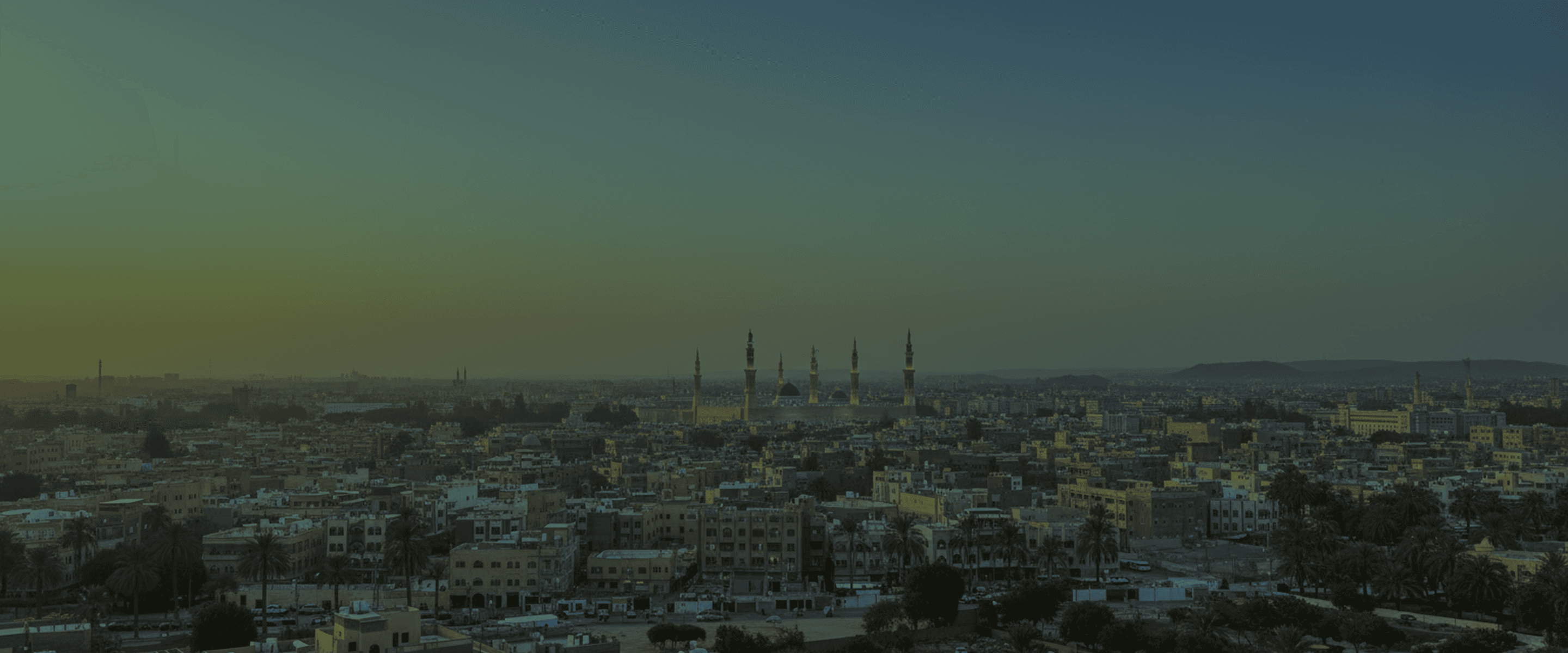 Al-Madinah at dusk, the minarets of Masjid al-Nabawi rising above the city